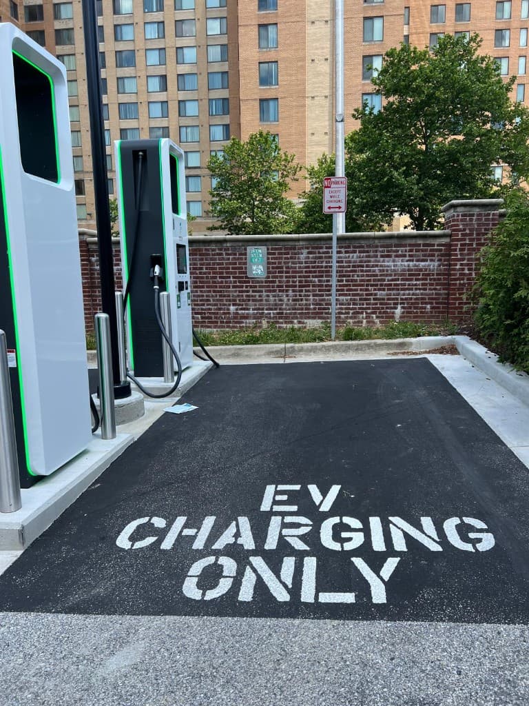 Modern EV chargers with EV CHARGING ONLY pavement marking at American Mega Laundromat